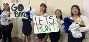 Cheerleaders holding a sign that says "Let's Hunt!"