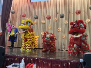 3 lion dancers on stage.