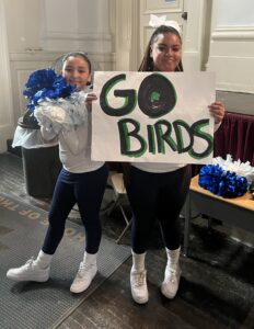 Cheerleaders holding a sign that says "Go Birds"