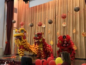 3 lion dancers on stage.