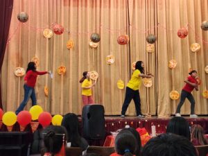 4 students performing a Chinese folk dance