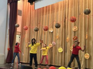 4 students performing a Chinese folk dance.