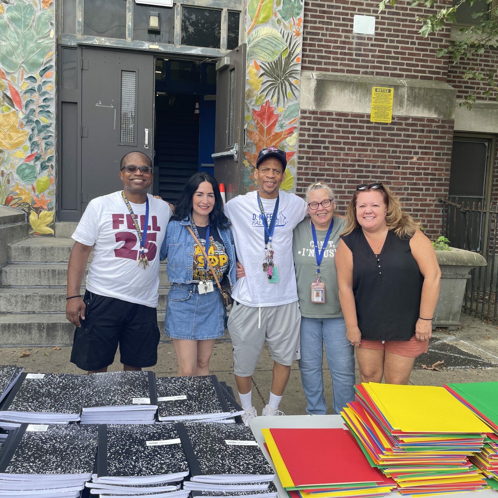 Staff of Fell Elementary Staff of Fell Elementary behind the table of school supplies.